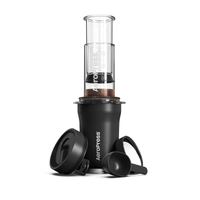 AeroPress Go Plus coffee maker with its components including the main chamber, plunger, filter cap, scoop, and stirrer. The AeroPress is shown assembled with coffee grounds inside.