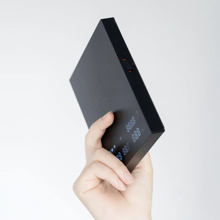 Slim 20mm profile of the Timemore Black Mirror Basic 3.0 coffee scale held in hand showing multifunction slider