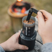 AeroPress Go brewer brewing coffee, person stirring coffee slurry with included stirrer