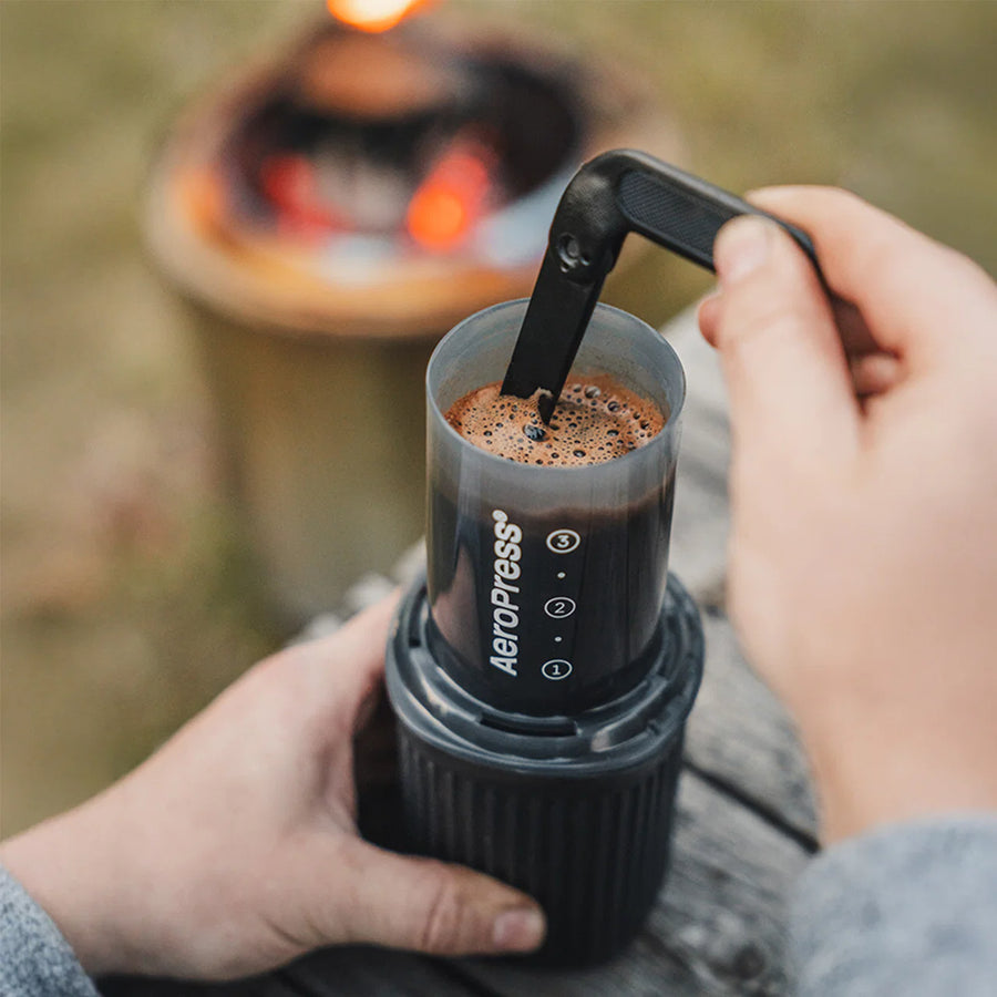 AeroPress Go brewer brewing coffee, person stirring coffee slurry with included stirrer