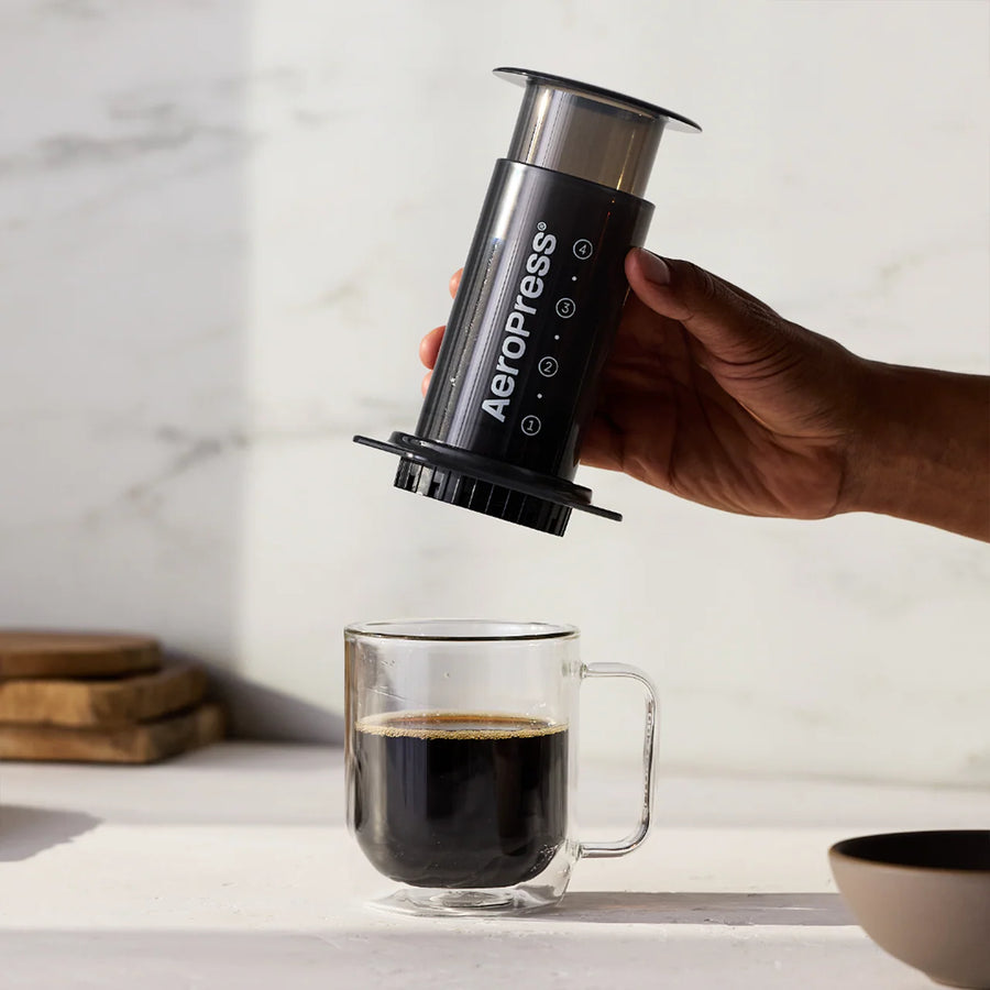 AeroPress classic coffee brewer after brewing coffee into a glass mug