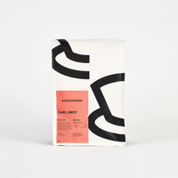 A packaged bag of Good & Proper Earl Grey loose leaf tea with a minimalist design, featuring white, pink and black colours.