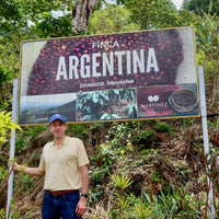 Alejandro Martinez standing proudly with his new signage at Finca Argentina in El Salvador