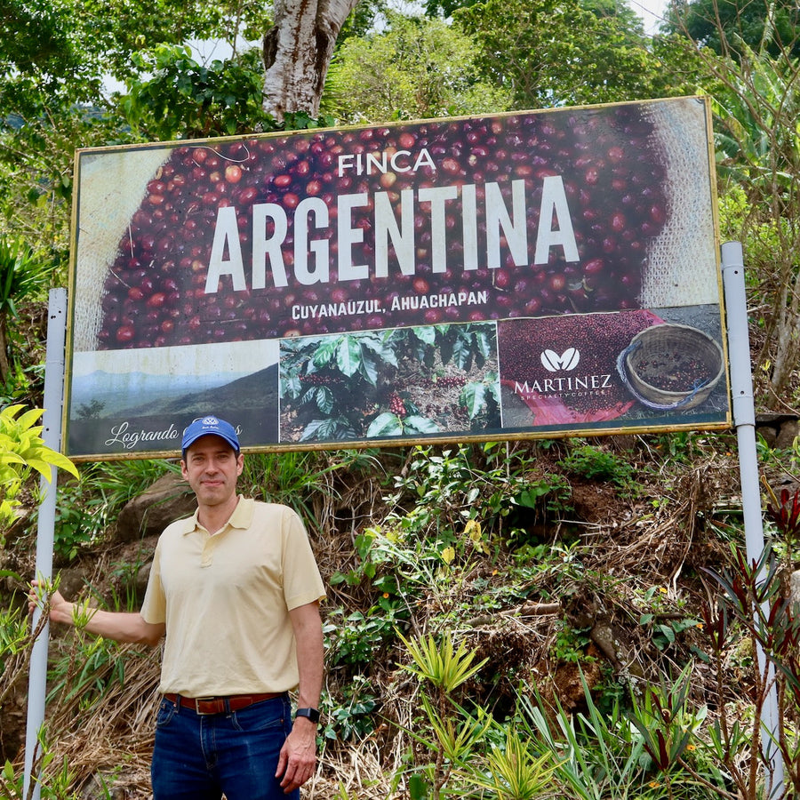 Alejandro Martinez standing proudly with his new signage at Finca Argentina in El Salvador