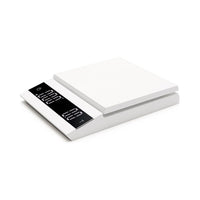 A white, parallel-style coffee scale with a digital display, showing its capacity and a 0.1g measurement marking.